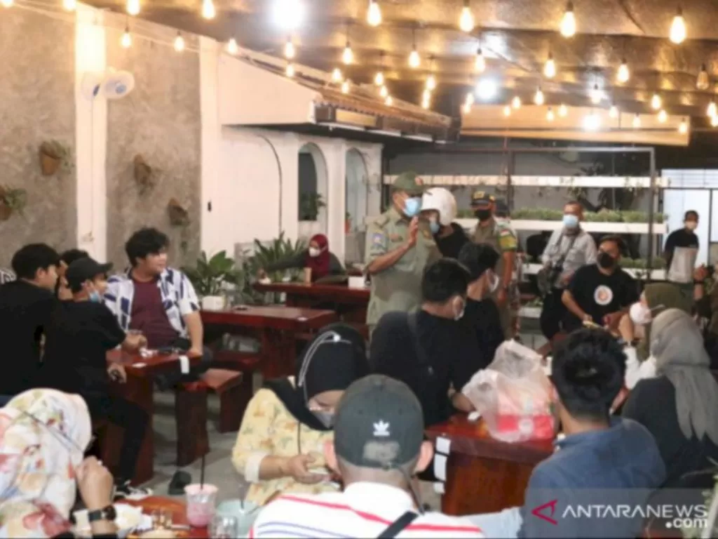 Ilustrasi tim prokes dan PPKM Mikro membubarkan pengunjung kafe. (ANTARA/HO)