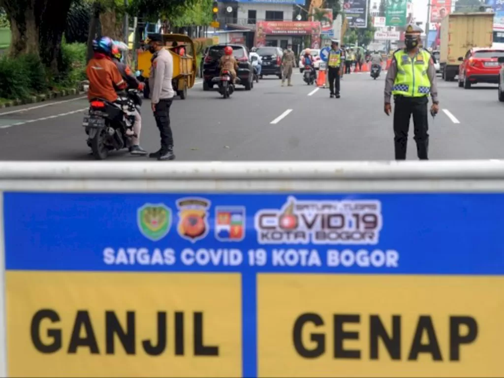 Anggota Polresta Bogor Kota mengatur arus lalu lintas saat pemberlakuan sistem gage di Simpang Baranangsiang, Kota Bogor. (ANTARA FOTO/Arif firmansyah)