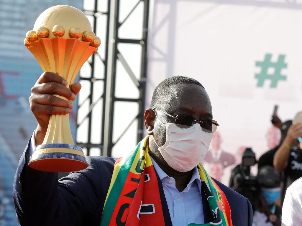 Presiden Senegal Macky Sall menggenggam trofi Piala Afrika 2021. (REUTERS/Zohra Bensemra)