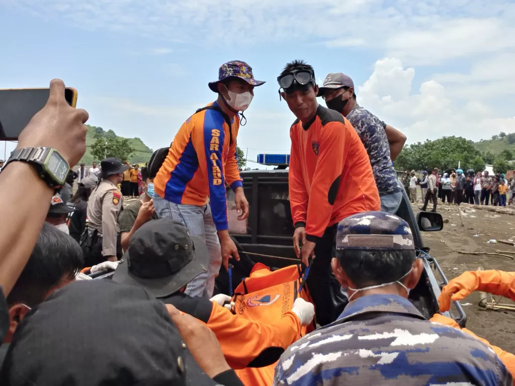 Tim SAR gabungan membawa korban terseret arus di Pantai Payangan, Desa Sumberejo, Ambulu, Jember, Jawa Timur, Minggu (13/2/2022).  (ANTARA FOTO/Wahyu)