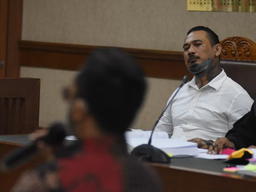 Terdakwa musisi I Gede Ari Astina atau Jerinx SID mendengarkan keterangan saksi ahli saat menjalani sidang lanjutan kasus pengancaman kepada Adam Deni di PN Jakarta Pusat. (ANTARA FOTO/Indrianto Eko Suwarso)