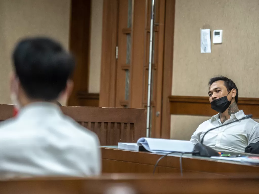 Terdakwa kasus pengancaman I Gde Ari Astina atau Jerinx SID mendengarkan keterangan saksi saat mengikuti persidangan di Pengadilan Negeri Jakarta Pusat. (ANTARA FOTO/Muhammad Adimaja)