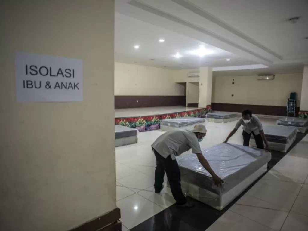 Petugas menyiapkan tempat tidur di GOR Tanjung Priok yang menjadi lokasi isolasi. (ANTARA FOTO/Aprillio Akbar)