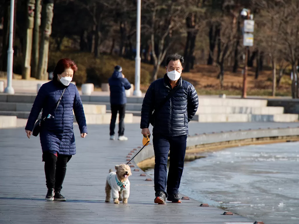 Dua warga mengenakan masker saat jalan-jalan di sekitar taman Seoul. (REUTERS/ Heo Ran)
