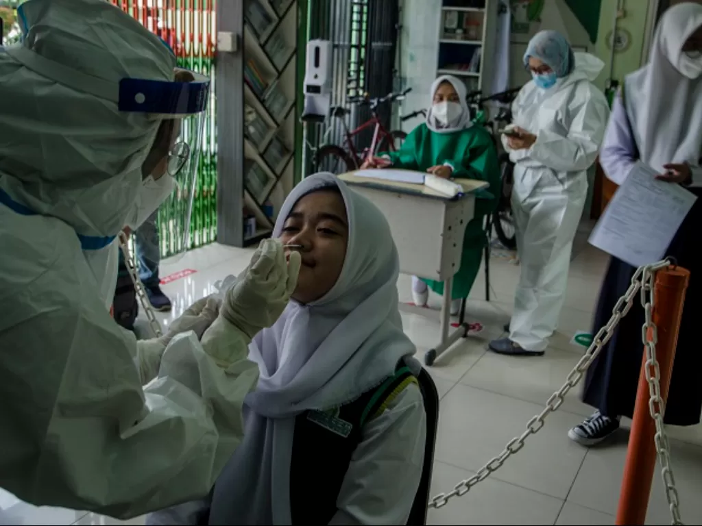 Petugas kesehatan mengambil sampel tes usap Antigen COVID-19 pelajar di SMP Assalaam, Bandung, Jawa Barat. (ANTARA FOTO/Novrian Arbi)