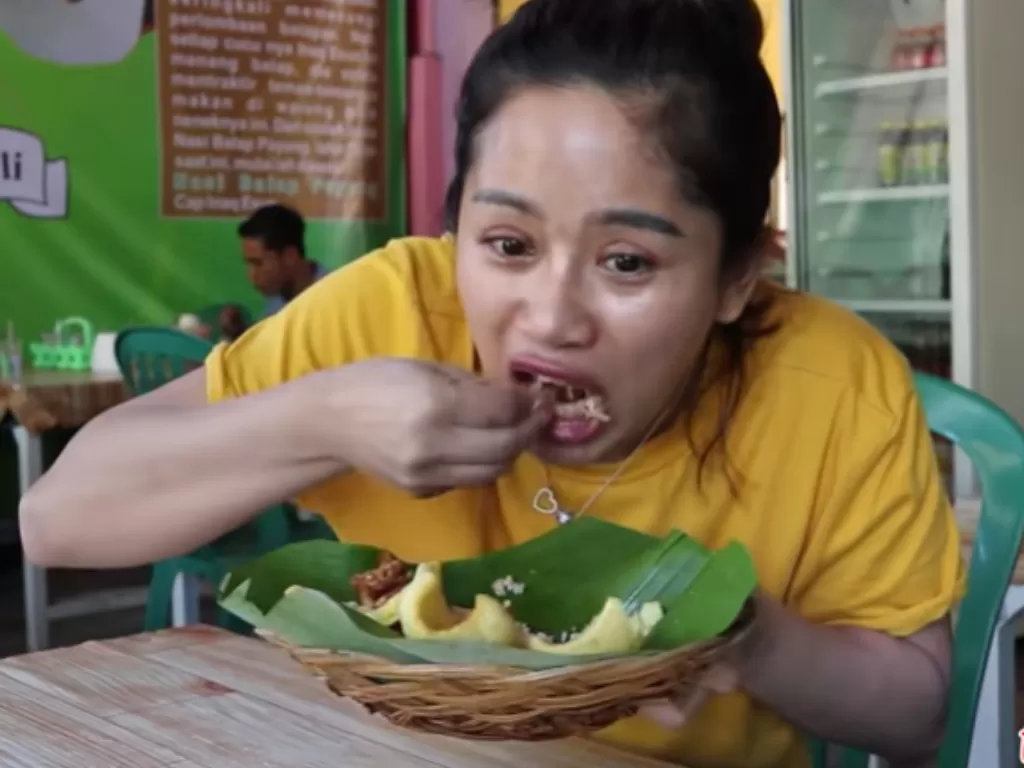 Farida Nurhan makan nasi balap puyung. (YouTube Farida Nurhan)