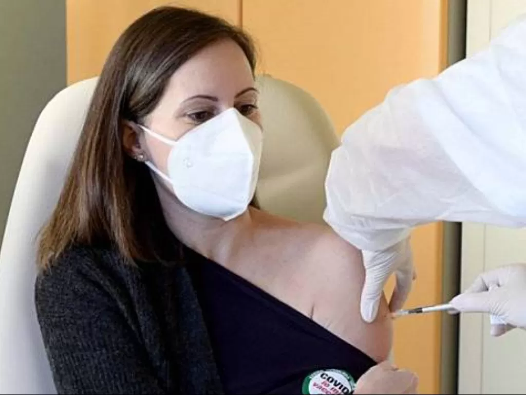 Seorang dokter, Francesca Pieralli, menerima vaksinasi COVID-19 di Rumah Sakit Careggi, Florence, italia, Minggu (27/12/2020). (REUTERS/Jennifer Lorenzini)