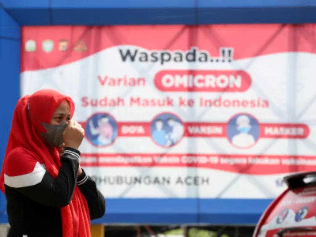 Warga memperbaiki posisi maskernya saat beraktivitas menyusul diperpanjangnya Pemberlakuan Pembatasan Kegiatan Masyarakat (PPKM) berbasis mikro di Banda Aceh, Aceh, Sabtu (19/2/2022). (ANTARA FOTO/Irwansyah Putra)