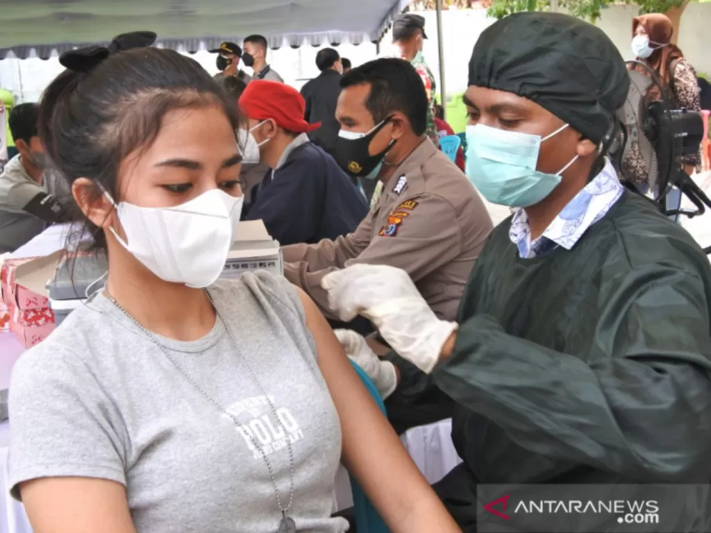 Seorang wanita pedagang disuntik vaksin COVID-19. (ANTARA/Aris Wasita)