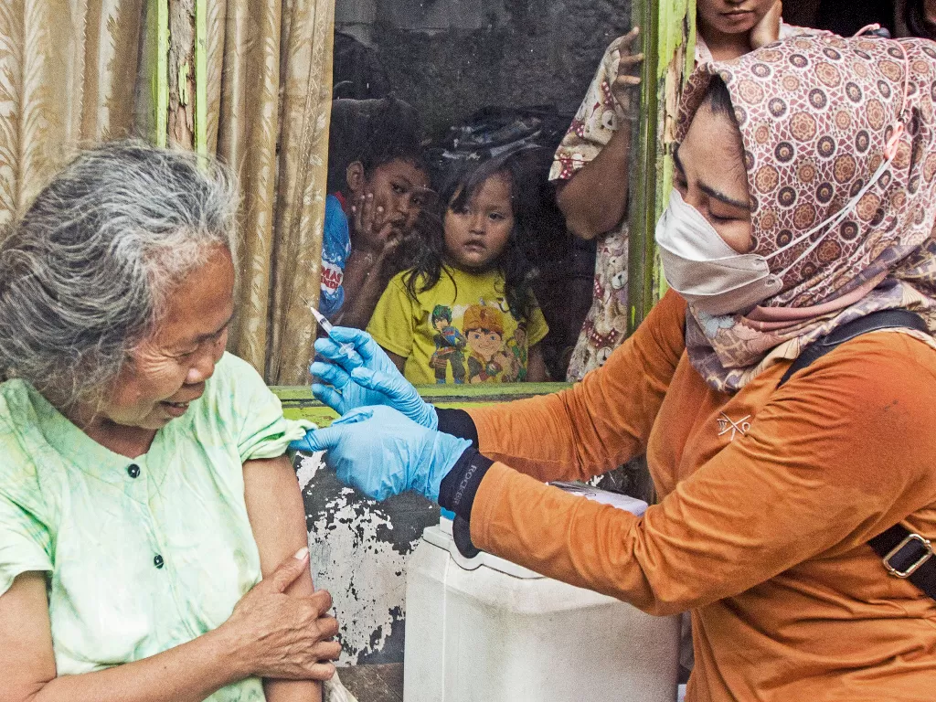 Petugas kesehatan menyuntikkan vaksin COVID-19 saat pelaksanaan vaksinasi lansia door to door di Kelurahan Plawad, Karawang, Jawa Barat, Jumat (18/2/2022). (ANTARA/Ibnu Chazar)