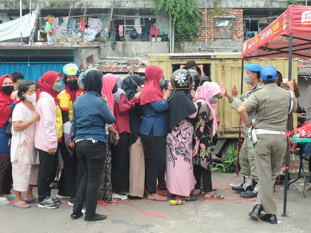 Warga antre membeli minyak goreng saat operasi pasar di Kawasan Rumah Susun Palembang, Sumatera Selatan, Kamis (24/2/2022). (ANTARA FOTO/Feny Selly)
