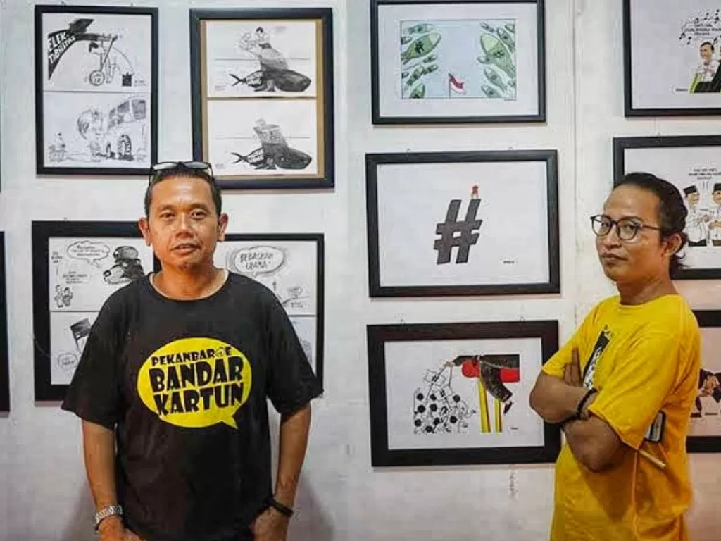 Furqon Lulus Wargi (berkaos hitam) kartunis dari Pekanbaru. (Riki Ariyanto/IDZ Creators)