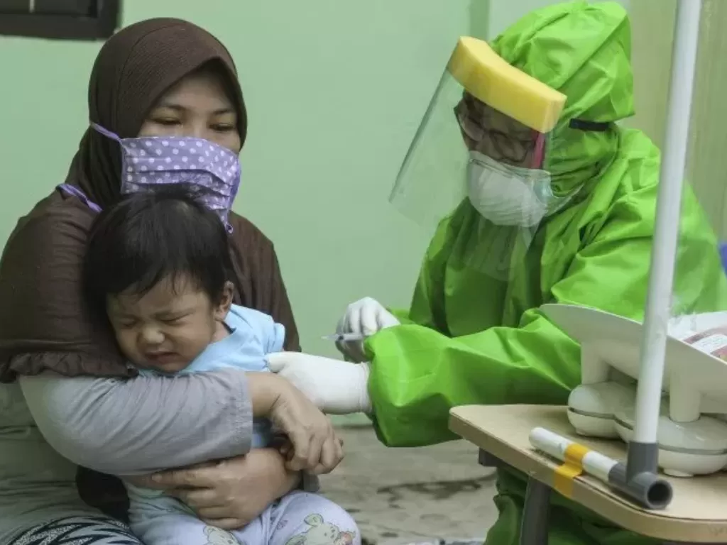 Seorang dokter mengenakan APD saat melakukan imunisasi kepada anak di Puskesmas Cisalak Pasar, Depok, Jawa Barat, Rabu (24/6/2020). ANTARA FOTO/Asprilla Dwi Adha. (Antara/Asprilla Dwi Adha)