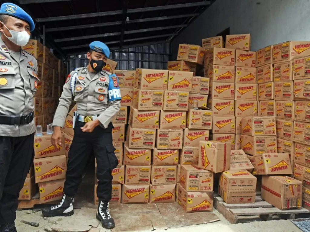 Polisi menjaga tumpukan kardus minyak goreng kemasan 2 liter yang diamankan dari sebuah gudang di Kabupaten Lebak, Banten. (ANTARA FOTO/Asep Fathulrahman)