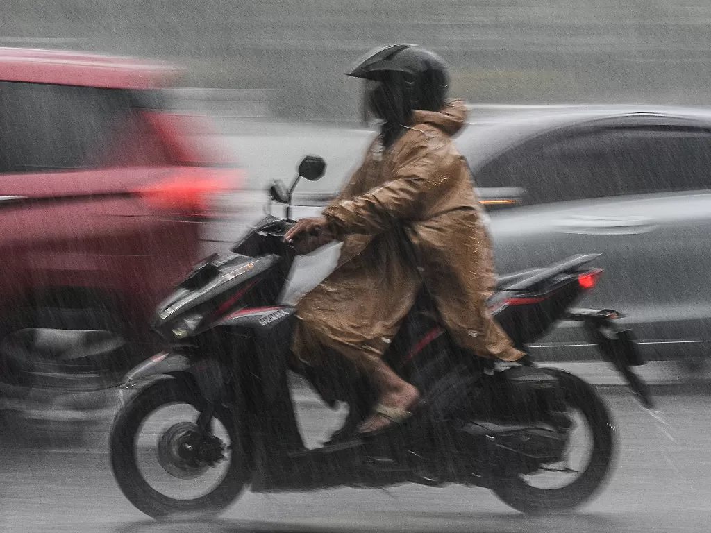 Seorang pengendara motor melintas saat hujan di kawasan Bundaran HI, Jakarta, Jumat (18/2/2022). (ANTARA/Fakhri Hermansyah)