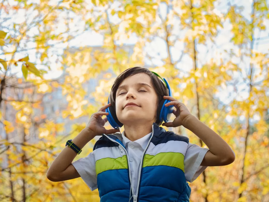 Ilustrasi anak mendengarkan lagu pakai headset. (Pexels/Jonas Mohamadi)