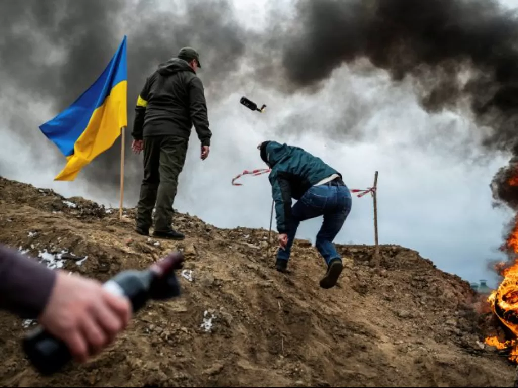 Seorang warga sipil berlatih melempar bom molotov saat invasi Rusia ke Ukraina di Zhytomyr. (REUTERS/Viacheslav Ratynskyi)