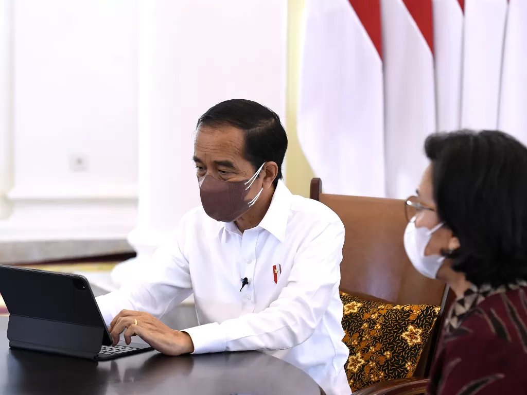 Presiden Joko Widodo (kiri) didampingi Menteri Keuangan Sri Mulyani saat mengisi Surat Pemberitahuan Tahunan (SPT) Pajak tahunan secara online di Istana Bogor, Jawa Barat, Jumat (4/3/2022). (ANTARA/BPMI Setpres-Kris)