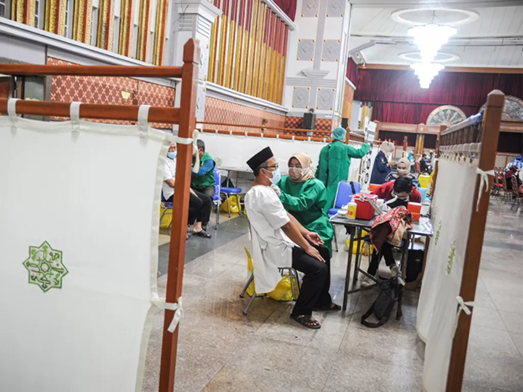 Seorang jamaah calon haji menjalani vaksinasi Covid-19 dosis ketiga di Pusdai, Bandung, Jawa Barat, Selasa (8/2/2022). (ANTARA FOTO/Raisan Al Farisi)