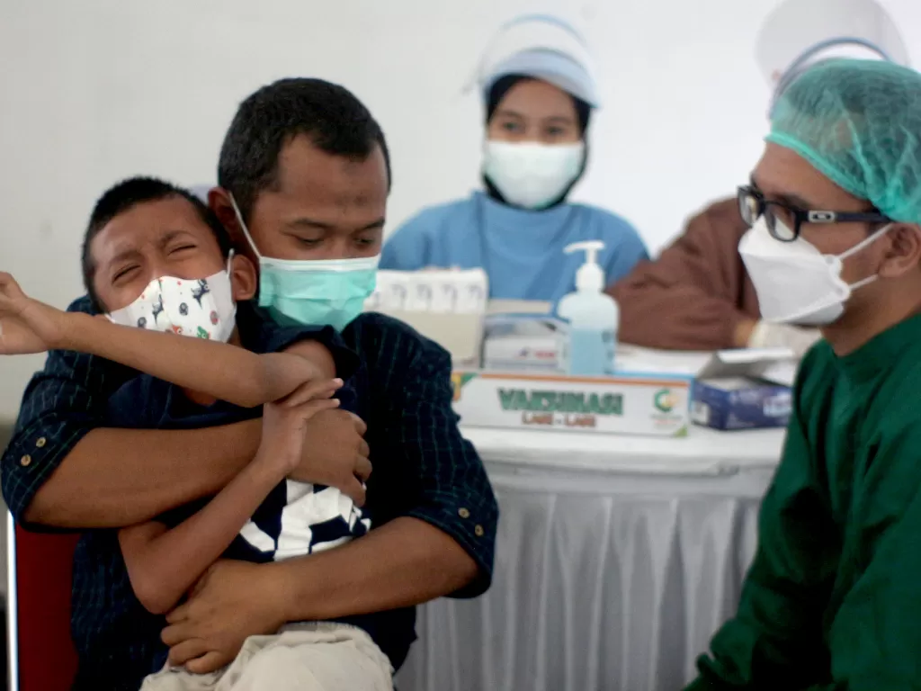 Seorang anak menangis saat akan mengikuti vaksinasi COVID-19 di Stadion Pakansari, Kabupaten Bogor, Jawa Barat, Sabtu (19/2/2022). (ANTARA/Yulius Satria Wijaya)
