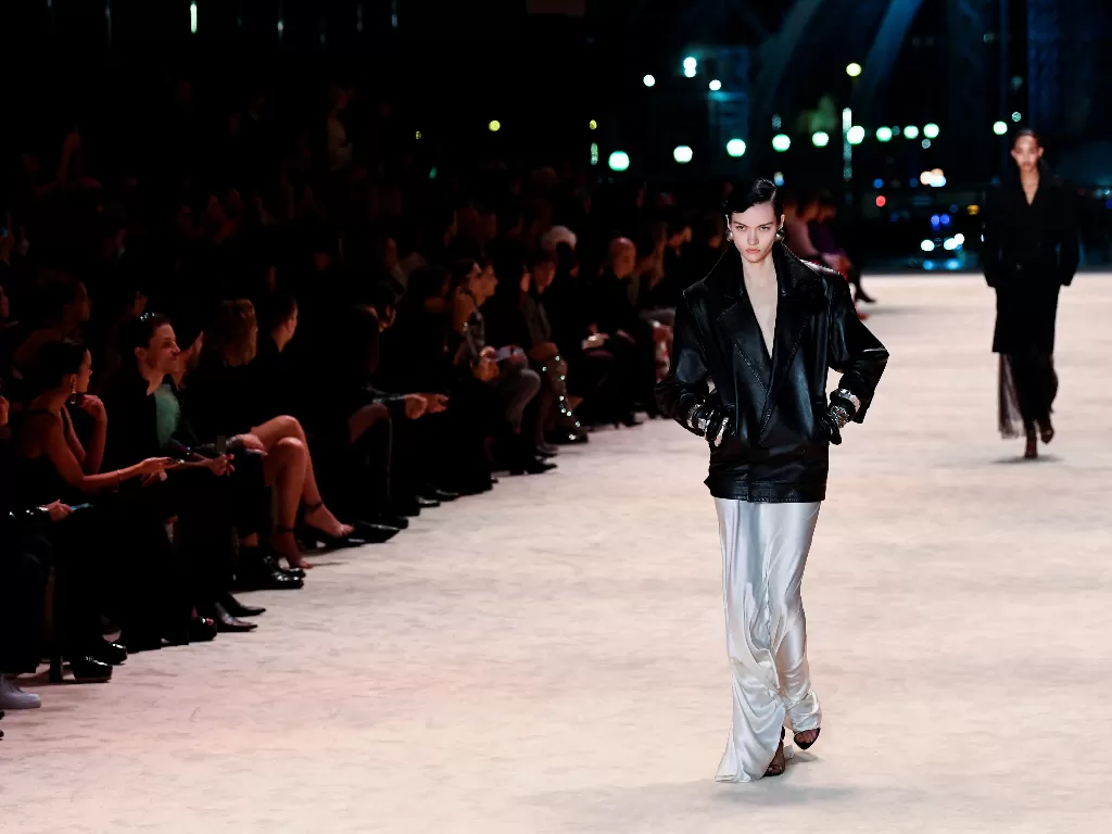 Para model mempersembahkan kreasi desainer Anthony Vaccarello sebagai bagian dari koleksi busana siap pakai Musim Gugur-Musim Dingin 2022/2023 untuk rumah mode Saint Laurent selama Paris Fashion Week di Paris, Prancis. (REUTERS/Piroschka van de Wouw)