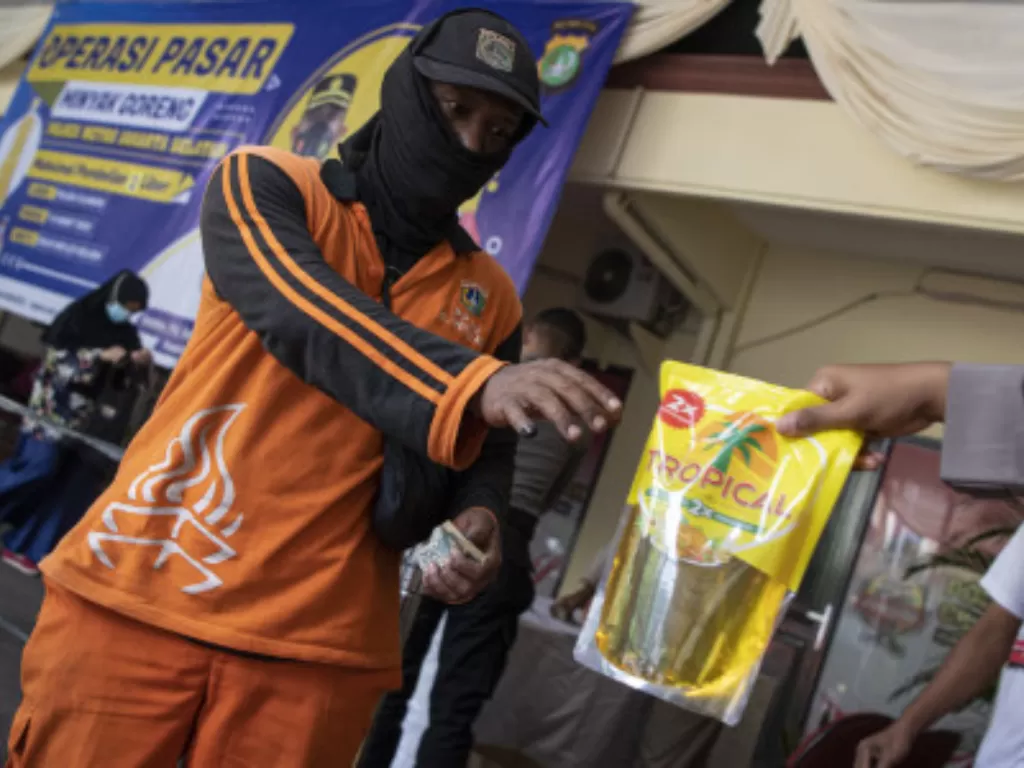Warga membeli minyak goreng dalam operasi pasar minyak goreng di Polsek Cilandak, Jakarta Selatan, Senin (7/3/2022). (ANTARA FOTO/Sigid Kurniawan)