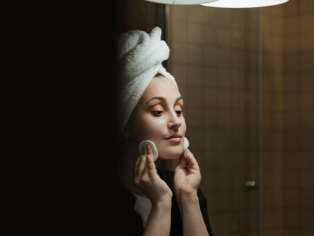 Ilustrasi wanita membersihkan wajah. (Pexels/Cottonbro)