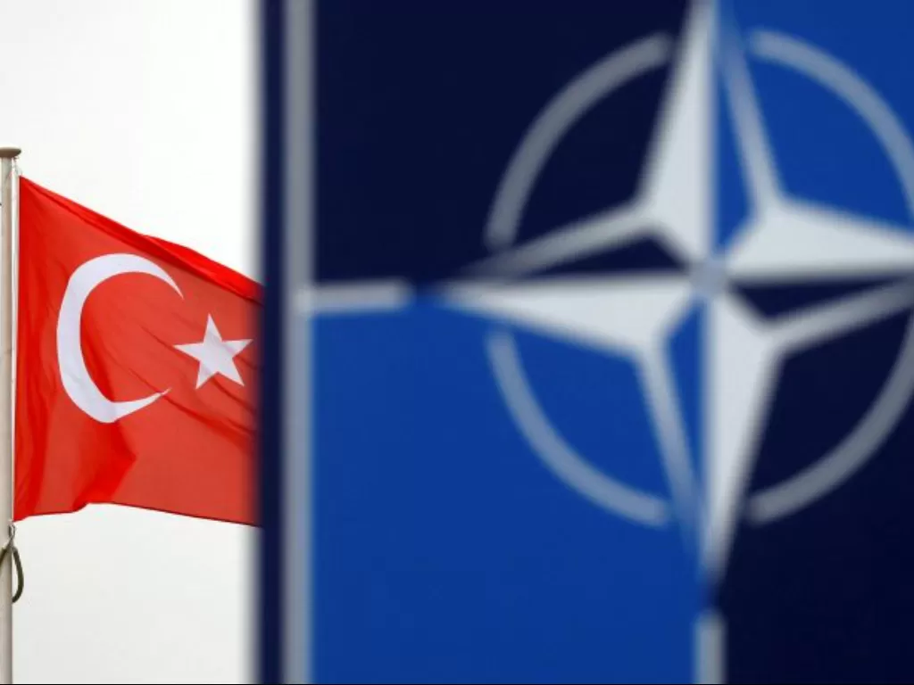 Bendera Turki berkibar di sebelah logo NATO di markas besar Aliansi di Brussels, Belgia. (REUTERS/Francois Lenoir)