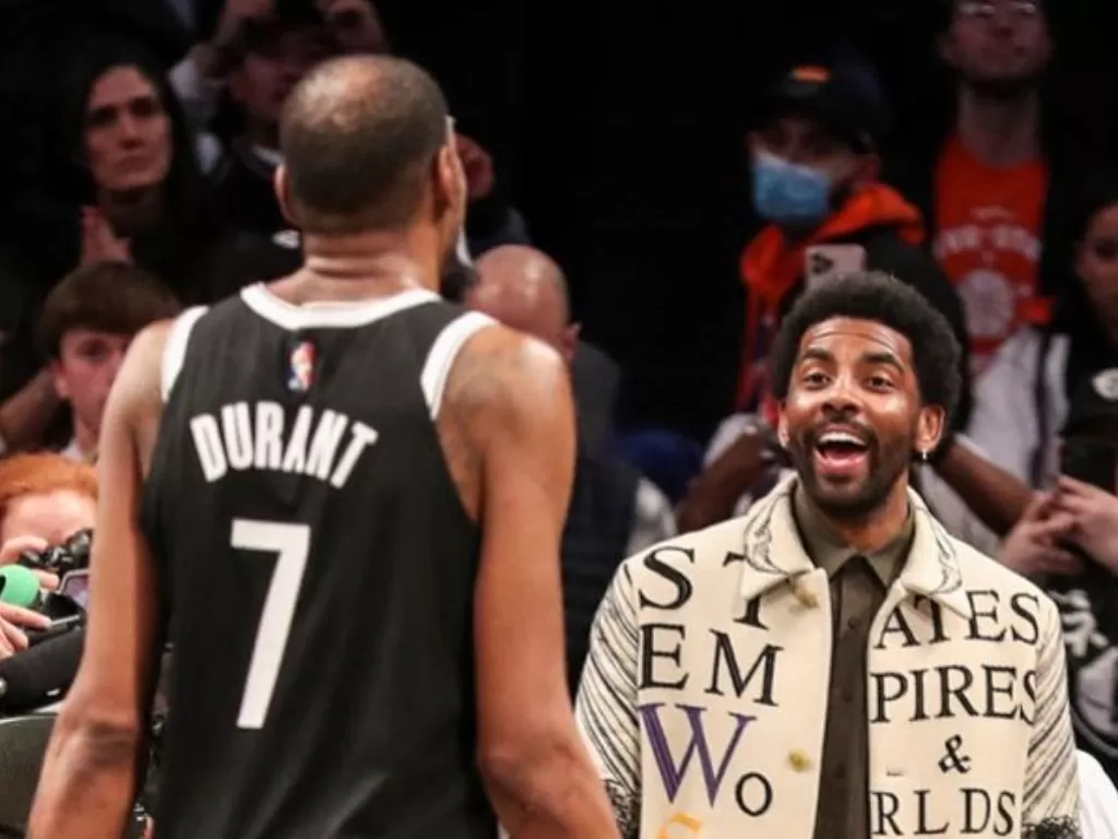 Bintang Brooklyn Nets Kyrie Irving (kanan), yang hanya diizinkan hadir sebagai penonton karena aturan mandat COVID-19 sektor privat, bersiap menyelamati rekannya Kevin Durant seusai mengalahkan New York Knicks dalam lanjutan NBA di Barclays Center, New Yo