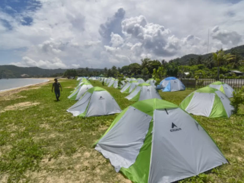Pengunjung berjalan di dekat tenda yang didirikan di area camping ground Kuta Beach Park The Mandalika, Kecamatan Pujut, Praya, Lombok Tengah, NTB, Rabu (9/3/2022). (ANTARA FOTO/Ahmad Subaidi)