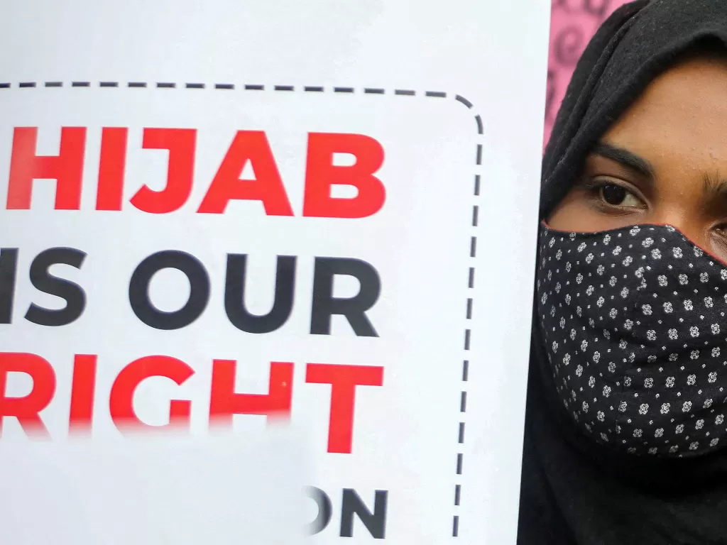 Seorang siswi Muslim memegang plakat saat protes oleh Federasi Pelajar Muslim (MSF) terhadap larangan jilbab di New Delhi, India. (REUTERS/Anushree Fadnavis)
