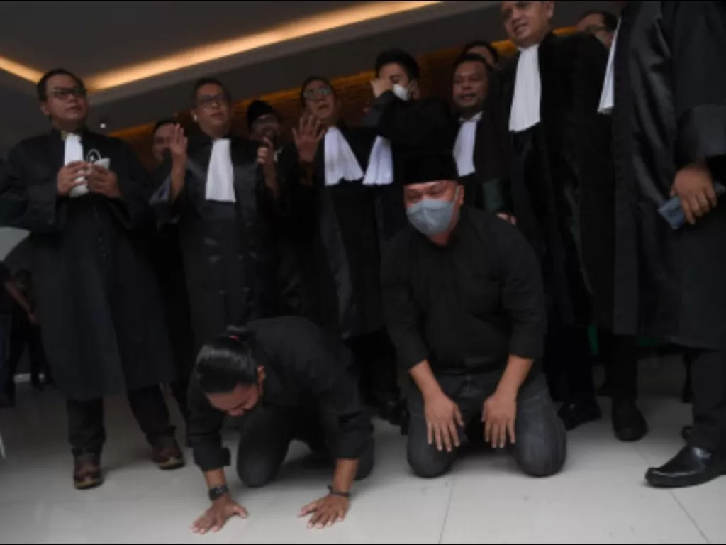 Terdakwa unlawful killing anggota Laskar FPI Briptu Fikri Ramadhan (kiri) dan Ipda M Yusmin Ohorella (kanan) melakukan sujud syukur seusai divonis bebas sidang putusan yang digelar secara virtual di Jakarta, Jumat (18/3/2022). (ANTARA FOTO/Sigid Kurniawan