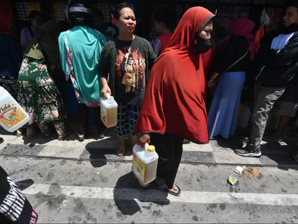 Warga antre membeli minyak goreng curah ke pedagang pengecer di Pasar Masomba di Palu, Sulawesi Tengah. (ANTARA FOTO/Mohamad Hamzah)
