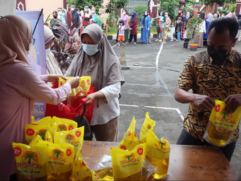 Warga mengantre membeli minyak goreng saat berlangsungnya operasi pasar minyak goreng di Mapolsek Pesanggrahan, Bintaro, Jakarta Selatan. (ANTARA FOTO/Muhammad Iqbal)