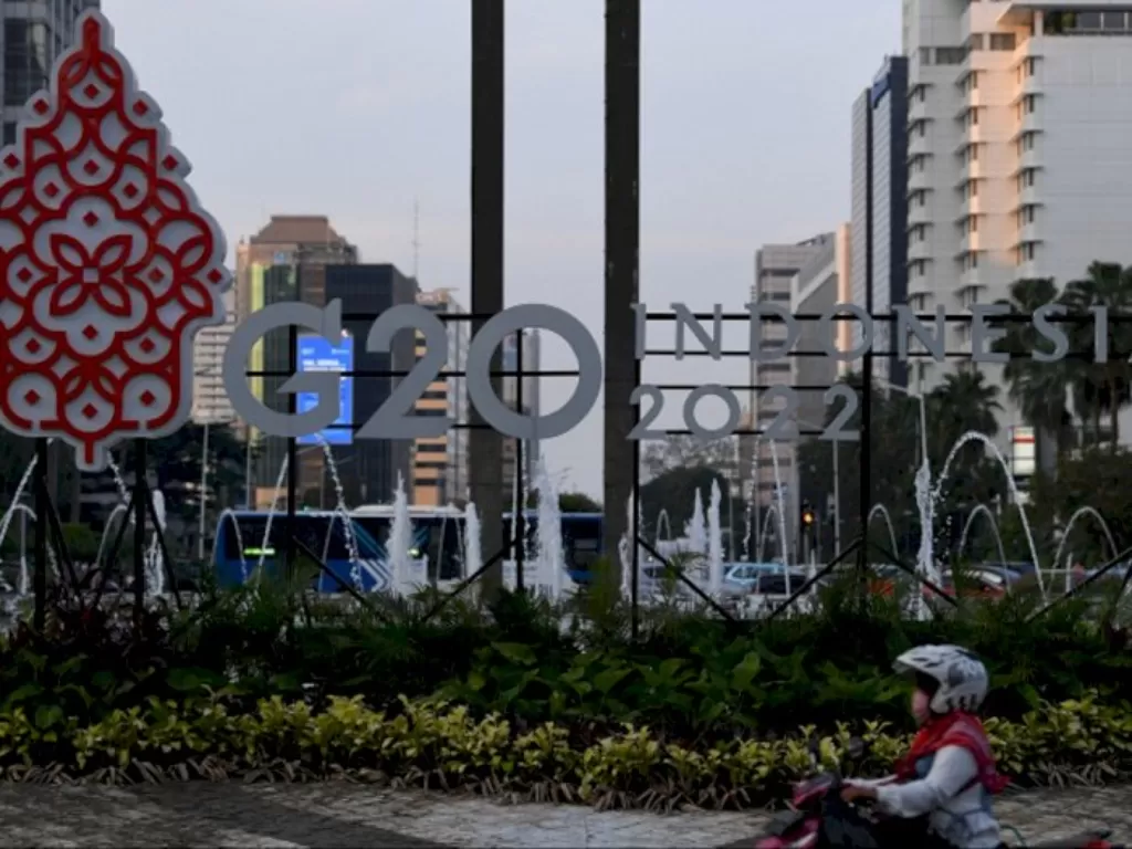 Pengendara motor melintas di depan logo Presidensi G20 Indonesia 2022 di Bundaran HI, Jakarta. (ANTARA FOTO/Sigid Kurniawan)