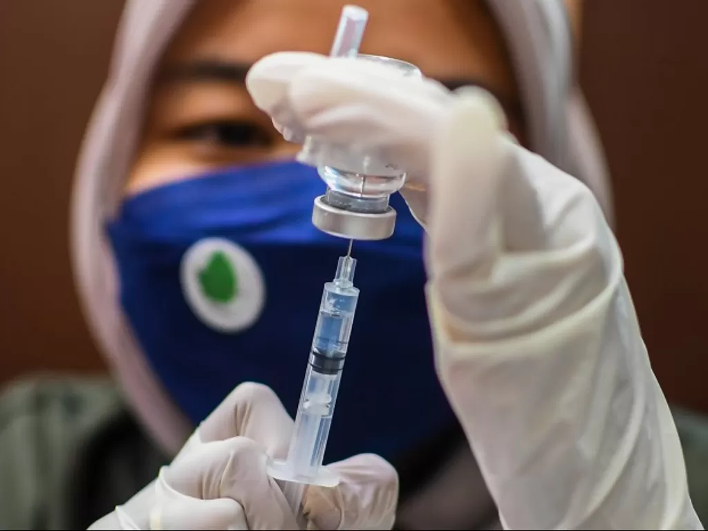 Nakes bersiap menyuntikkan vaksin COVID-19 dosis ketiga kepada warga saat vaksinasi booster Covid-19 di Sentra Vaksin Hippindo SMESCO, Jakarta. (ANTARA FOTO/Galih Pradipta)
