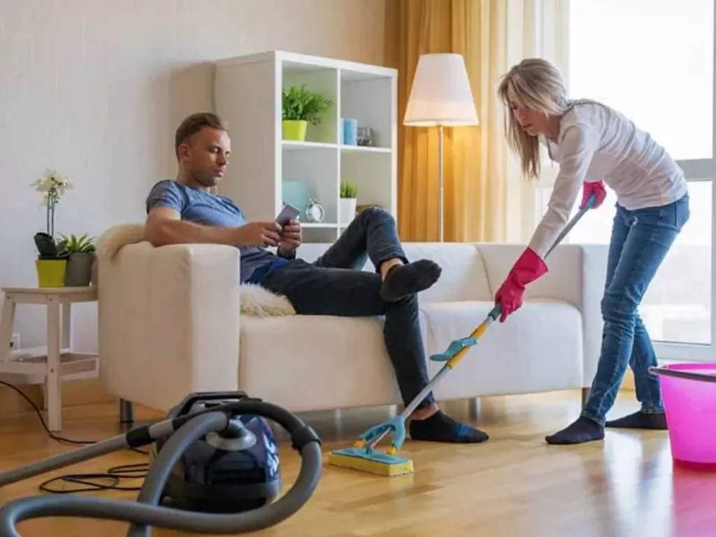 Ilustrasi suami bersantai saat istri sibuk membersihkan rumah. (Parenting.firstcry.com)