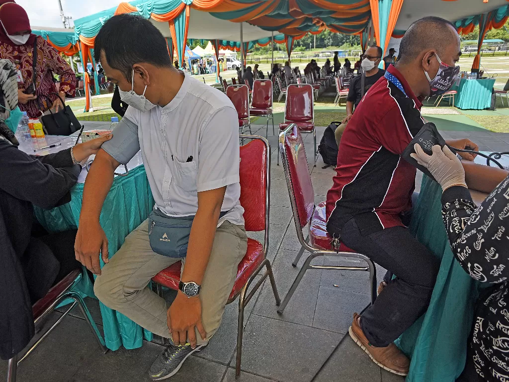 Petugas memerksa kesehatan warga yang mengikuti program Penuntasan Vaksinasi COVID-19 di Alun-alun Kota Cilegon, Banten, Kamis (24/3/2022). (ANTARA/Asep Fathulrahman)
