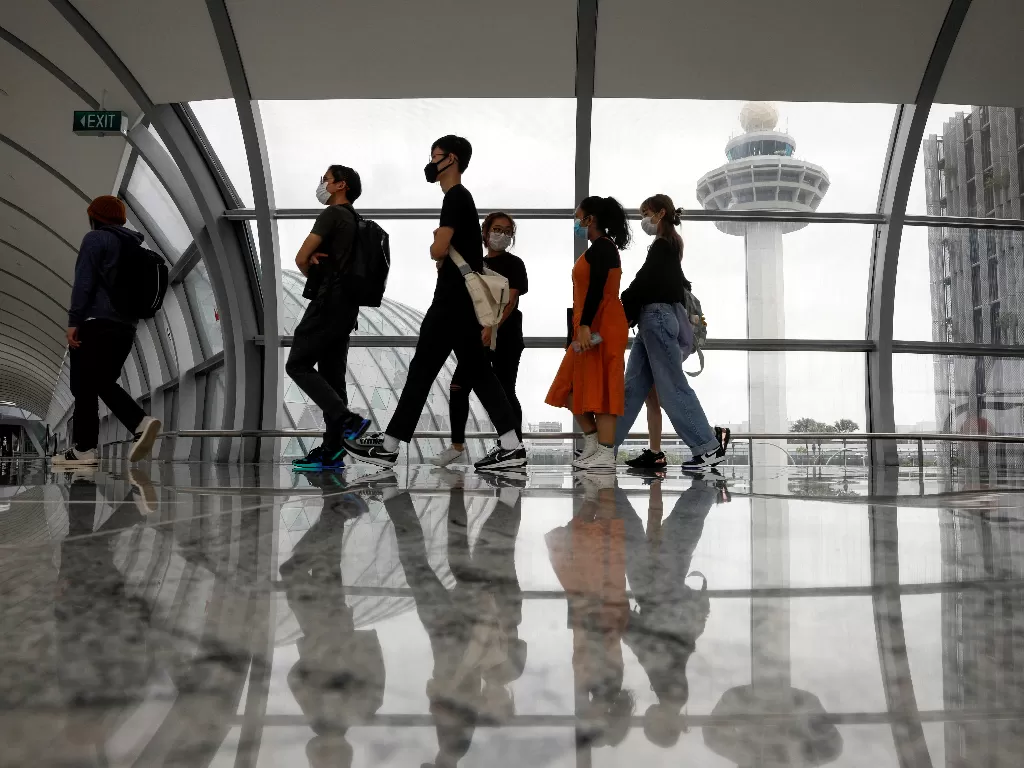 Orang-orang melewati menara kontrol Bandara Changi Singapura, Singapura 18 Januari 2021. (REUTERS/Edgar Su)