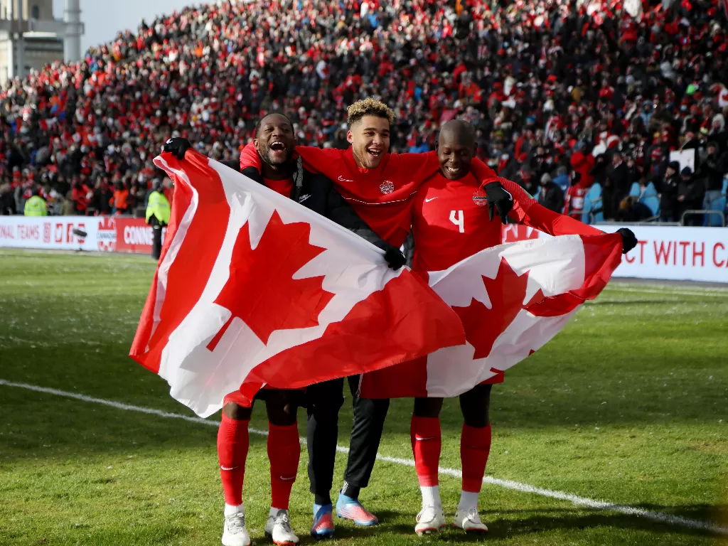 Pemain Kanada mengibarkan bendera usai lolos otomatis ke Piala Dunia 2022. (REUTERS/Carlos Osorio)