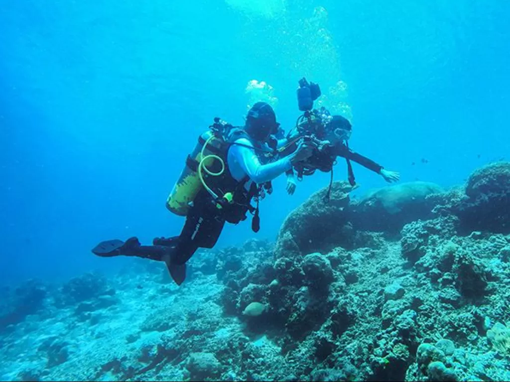 Seorang dive master (kiri) mendampingi wisatawan dari Surabaya menyelam di lokasi diving Koila di Negeri Morella Kabupaten Maluku Tengah, Provinsi Maluku, Minggu (27/3/2022). (Foto/Antara)