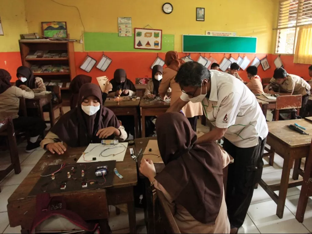 Guru memberi arahan kepada seorang siswi saat mengikuti PTM SDN Pondok Pinang 01. (ANTARA FOTO/Reno Esnir)