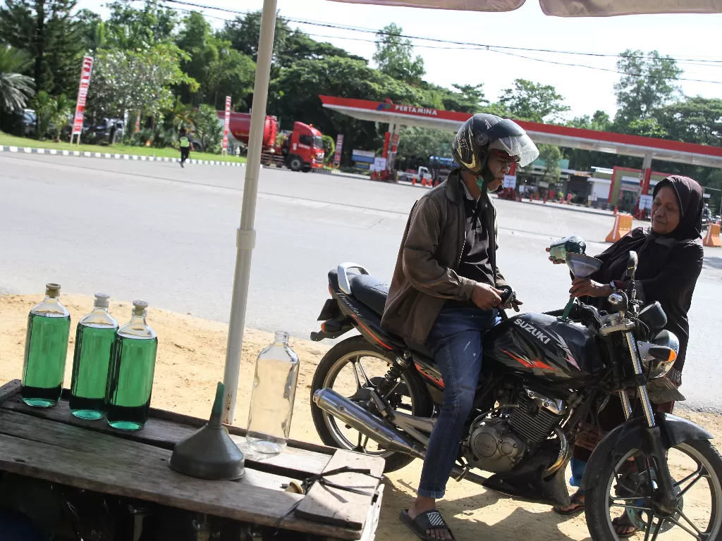 Pengendara mengisi BBM Pertalite botolan di depan SPBU di Kendari, Sulawesi Tenggara, Senin (4/4/2022). (ANTARA FOTO/Jojon)