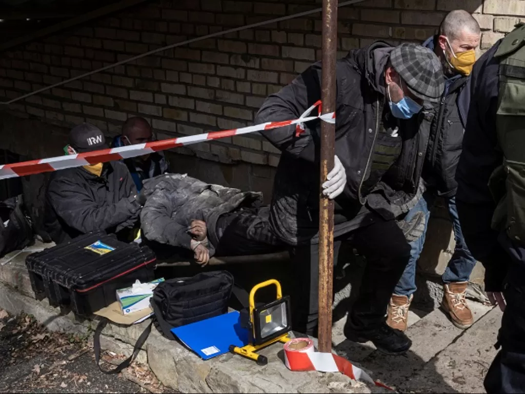 Relawan membawa kantong mayat di Bucha, Ukraina. (REUTERS/Stringer)
