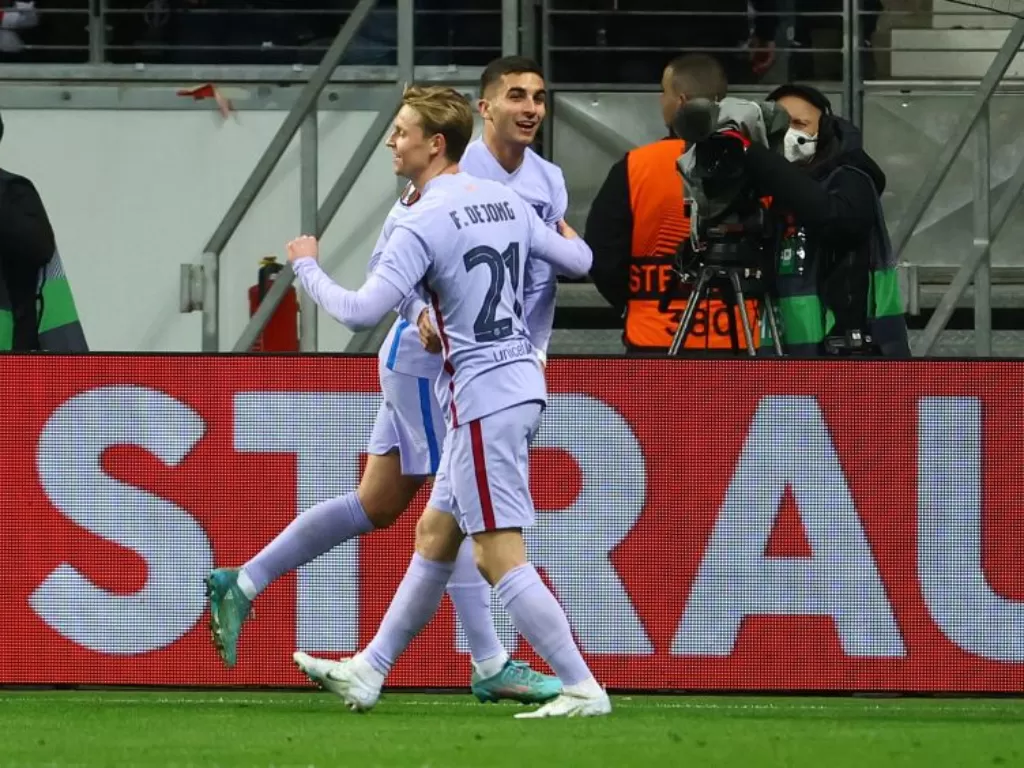 Frankie De Jong dan Ferran Torres usai mencetak gol pada laga Frankfurt vs Barcelona, Jumat (8/4/2022). (REUTERS/Kai Pfaffenbach)