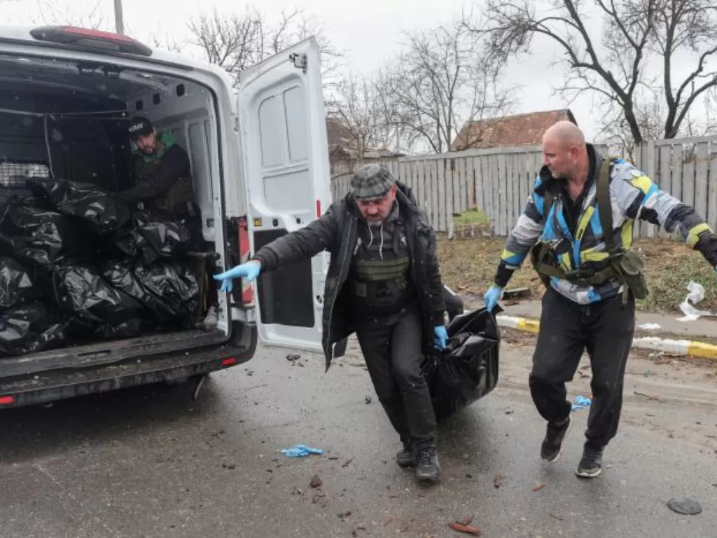 Relawan membawa kantong mayat di Bucha, Ukraina. (REUTERS/Stringer)