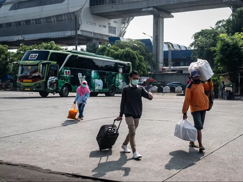 Calon penumpang berjalan menuju bus antarkota antarprovinsi (AKAP) di Terminal Kampung Rambutan, Jakarta. (ANTARA FOTO/Aprillio Akbar)