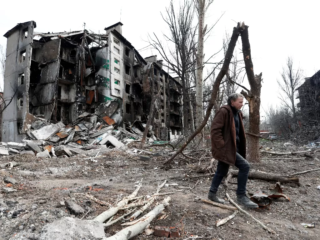 Seorang pria berjalan di reruntuhan  bangunan di Mariupol, Ukraina (REUTERS/Alexander Ermochenko)