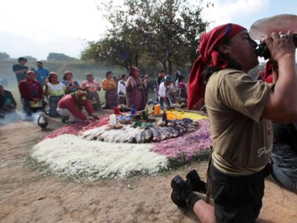 Pendeta Maya membunyikan nada melalui cangkang keong dalam upacara Oxlajuj Batz untuk memperingati berakhirnya kalender Maya di pusat upacara Kaminal Juyu, Kota Guatemala. (REUTERS/William Gularte)