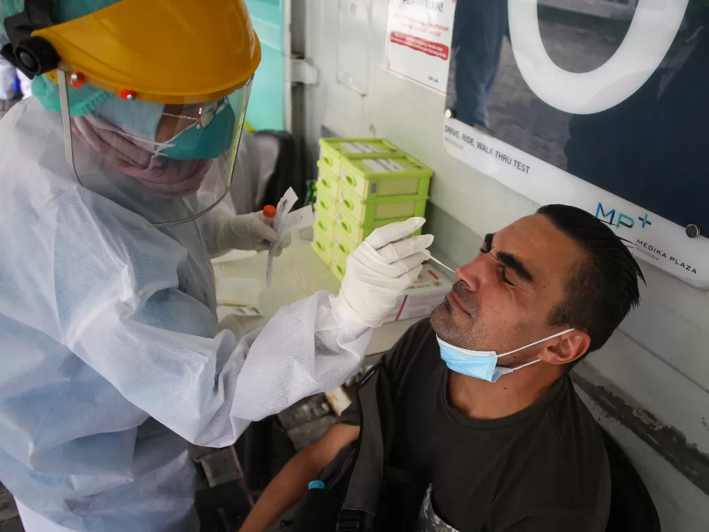 Petugas medis melakukan tes usap PCR kepada seorang warga di Laboratorium Genomik Solidaritas Indonesia, Cilandak, Jakarta, Selasa (15/3/2022). (ANTARA/Rivan Awal Lingga)